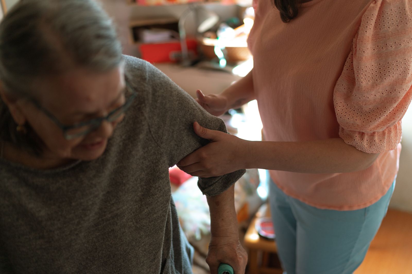 Caregiver supporting an older woman at home